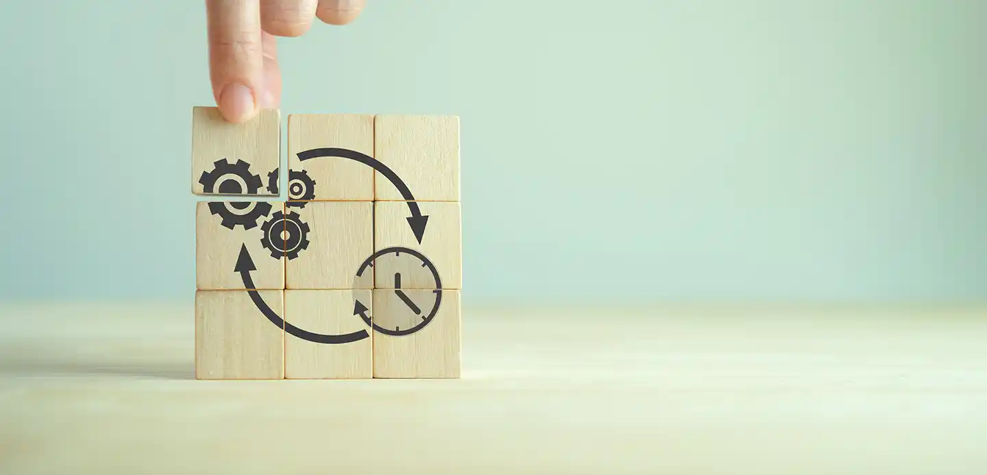 Wooden blocks with gear, arrow, and clock icons representing a streamlined CAT engine rebuild process and reduced lead times compared to purchasing a new engine.