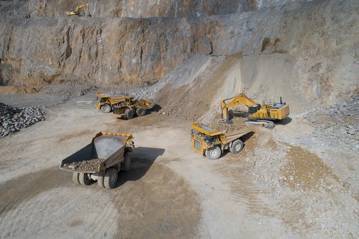 CAT mining haul trucks and excavators working in an open-pit mine, illustrating the importance of reliable equipment in mining operations.